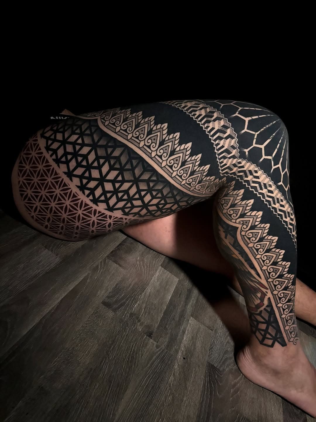 Intricate blackwork geometric tattoo covering legs and buttocks featuring mandala patterns, sacred geometry, hexagons, and ornate decorative borders