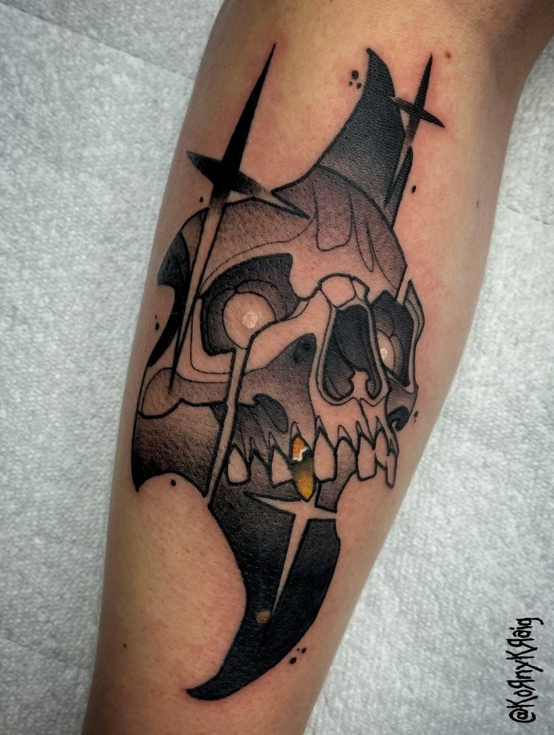 Neo-traditional black and grey tattoo of a skull with sword piercing through it, featuring dramatic shading and surrealist elements on forearm