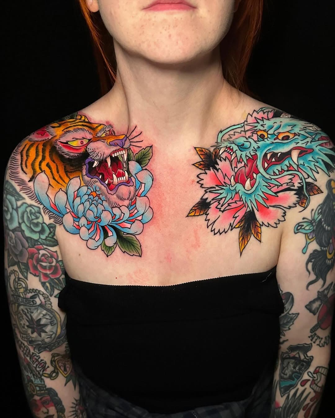 Neo-traditional chest tattoo featuring a roaring tiger with chrysanthemum and a turquoise dragon with pink peonies in vibrant colors