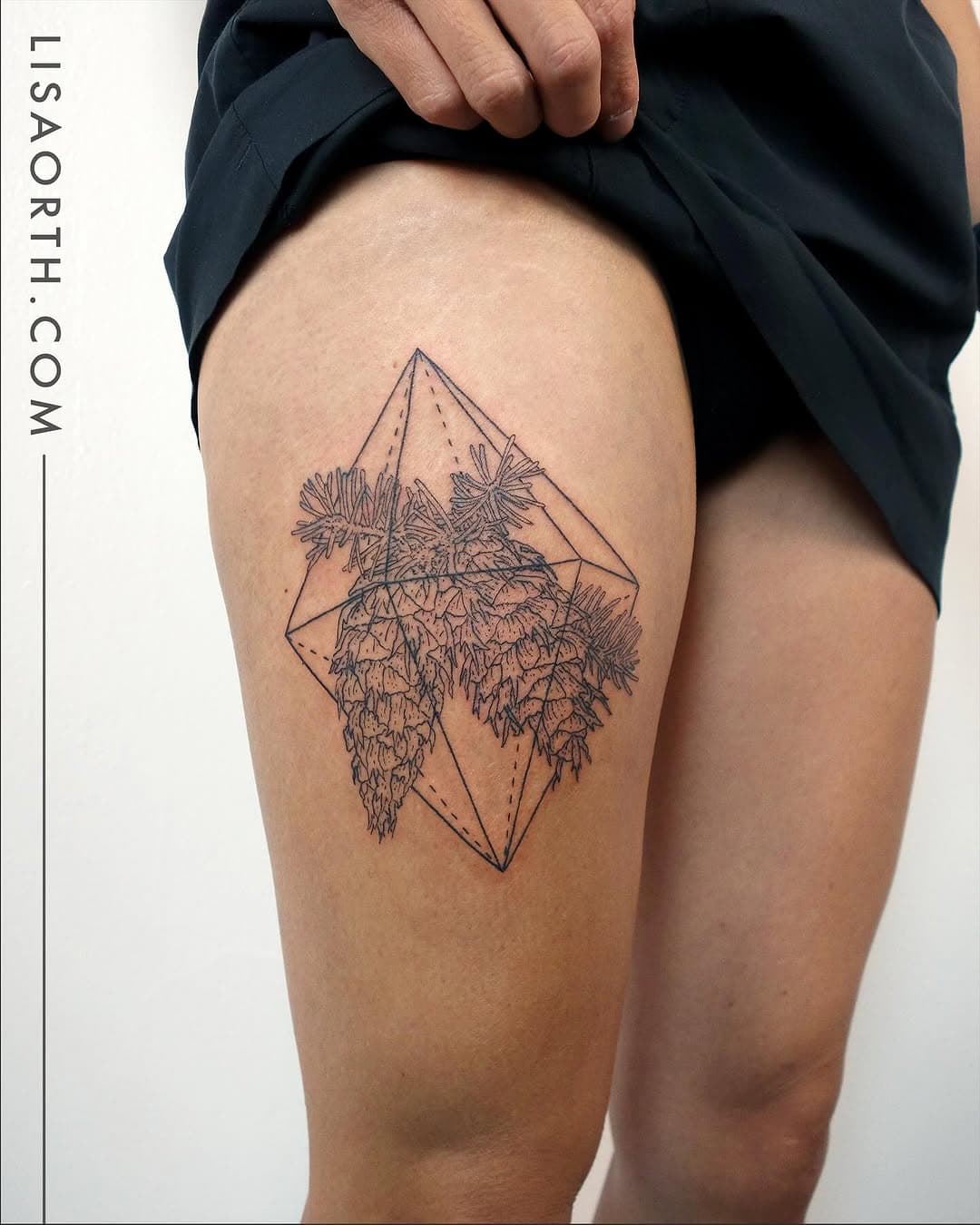 Fine-line geometric tattoo on thigh featuring palm trees enclosed within an angular diamond shape in illustrative black ink