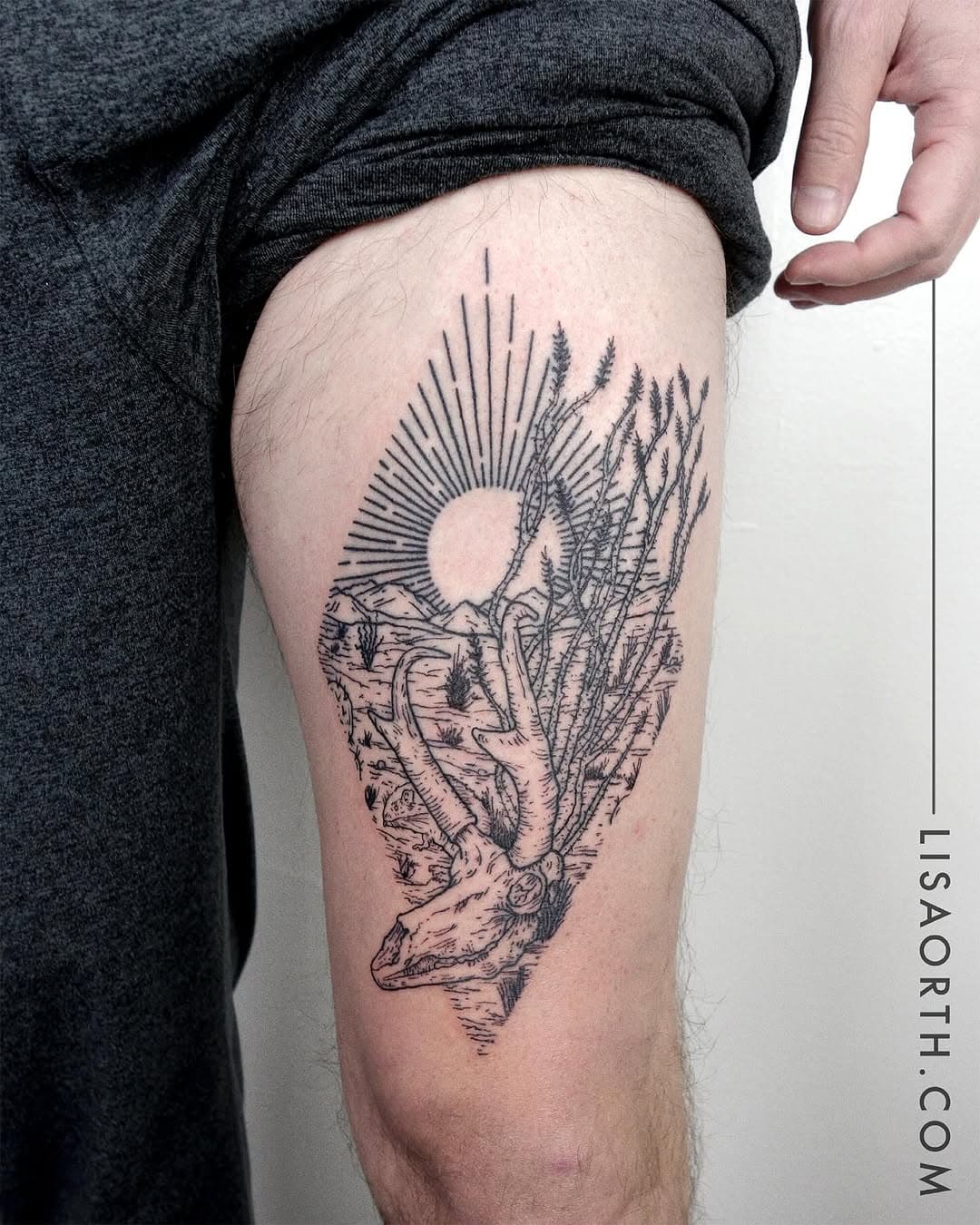 Black and grey desert landscape tattoo on thigh featuring cow skull, cacti, rock formations, and radiating sun in illustrative fine-line style