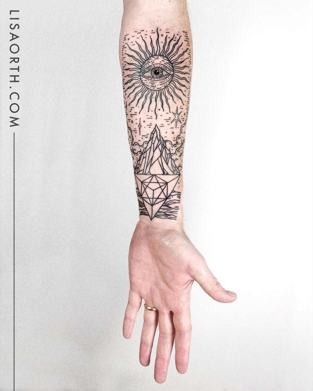 Forearm tattoo featuring an all-seeing eye with radiating sun rays above geometric mountains and sacred geometry designs in fine-line black ink